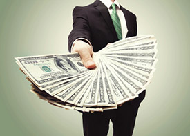 Businessman holding out a fan of cash